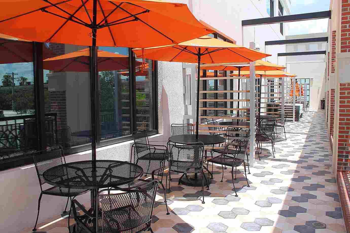 Balcony With Tables And Chairs And Orange Umbrella - Rof Inc