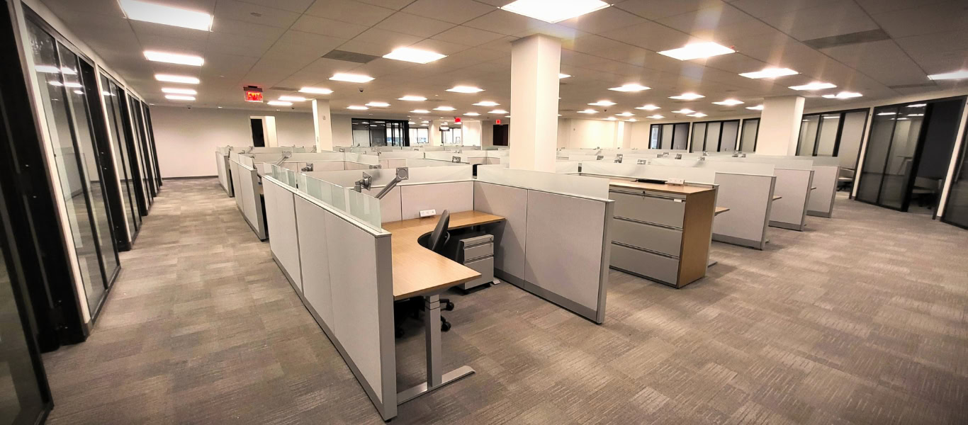 Finished open-plan office with curved perimeter private offices and rows of workstations, Melville, New York